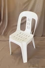 White plastic chair on a brown background.