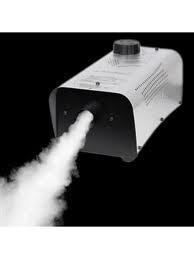 Fog machine releasing white fog against a black background.