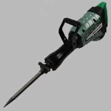 Electric jackhammer, green and black, with a long metal chisel, angled on a gray background.