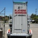 White trailer with R&R Hire Services logo, parked outdoors on a sunny day.