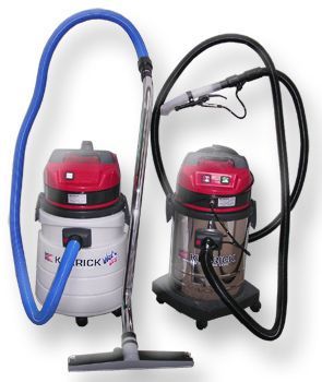 Two commercial vacuum cleaners, one white and one stainless steel, both with red tops and hoses.