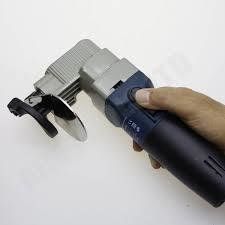 Hand holding a blue and gray electric metal shear.