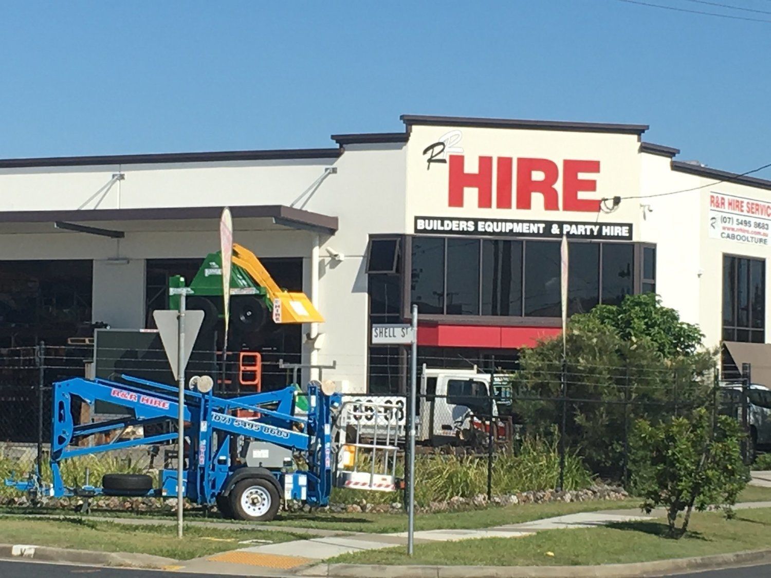 Building and party equipment hire shop with machinery out front.