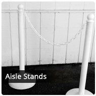 White aisle stands with a linked chain, in front of a wall.