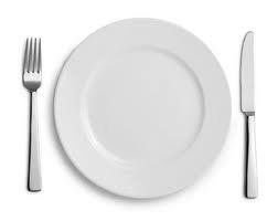White plate with fork and knife on a white background.
