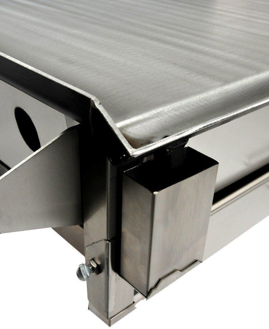 Close-up of a stainless steel griddle with a grease trap attached.