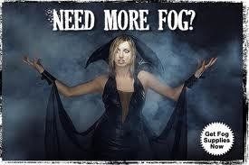 Blonde woman in black dress surrounded by fog, arms raised, asking if you 