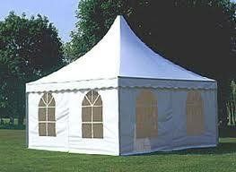 White tent with arched windows on green grass.