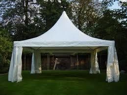 White tent with a pointed roof, set up on green grass.