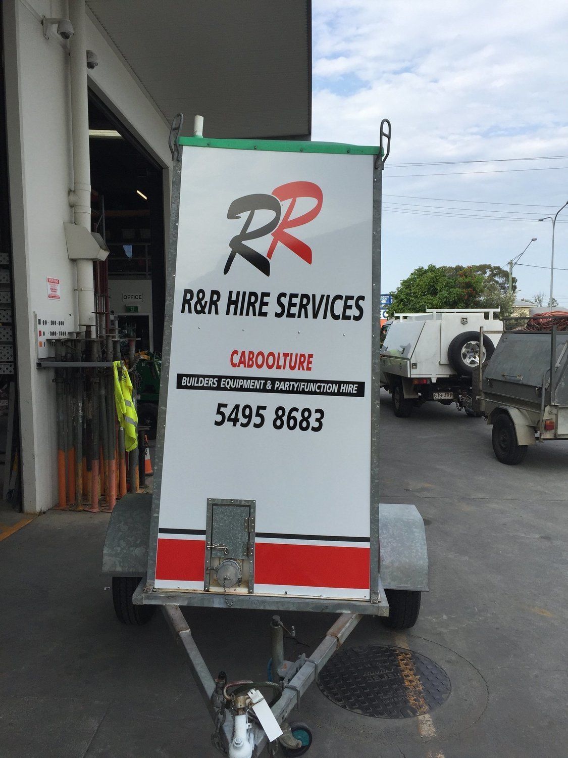 Trailer with R&R Hire Services logo on a white and red box. Green border with black lettering.