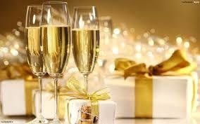 Champagne flutes with bubbly drink, presents with gold bows, celebratory setting.
