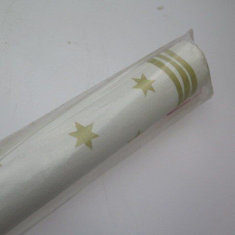 Rolled-up wrapping paper, white with gold stars and stripes, in a clear plastic wrapper.