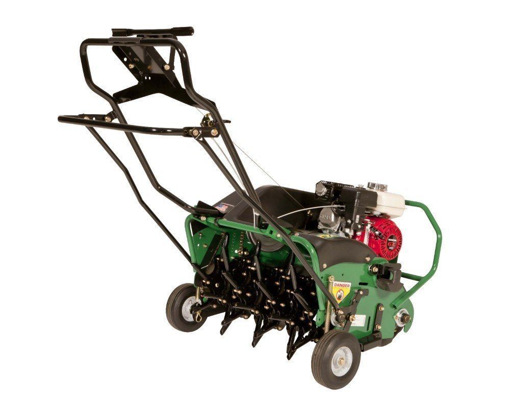 A walk-behind lawn aerator; green body, black handle, red engine, operating on grass.