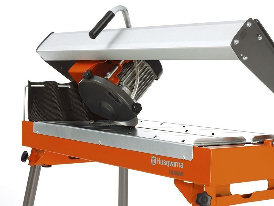 Orange and silver tile saw with blade, handle, and protective cover.