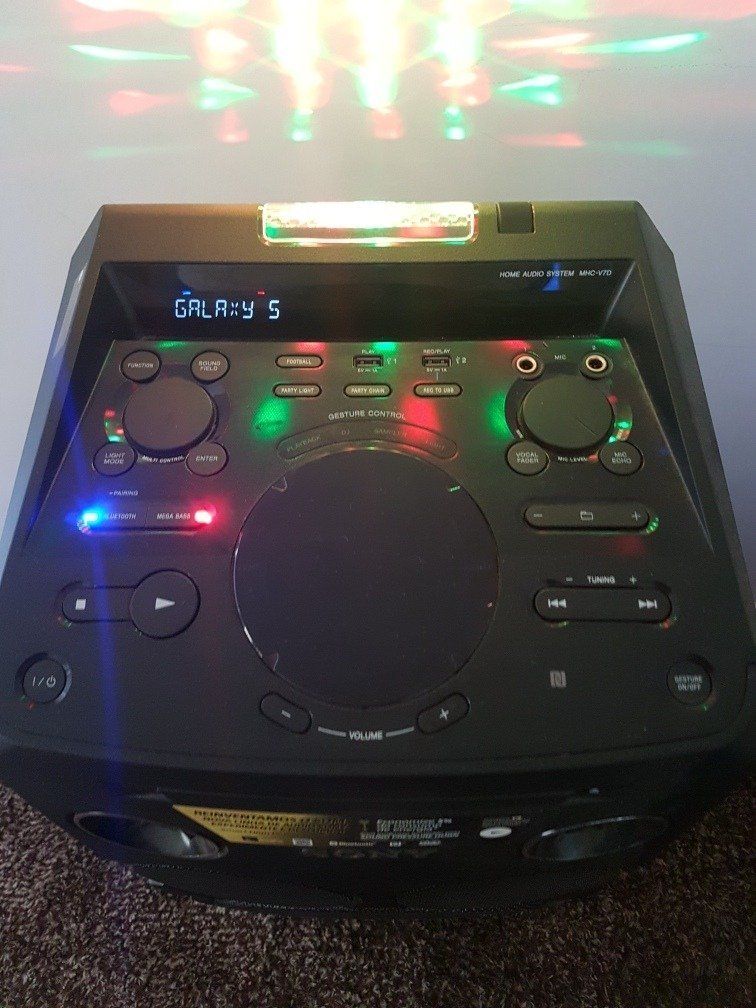 Black Sony party speaker with colorful lights illuminating the background.