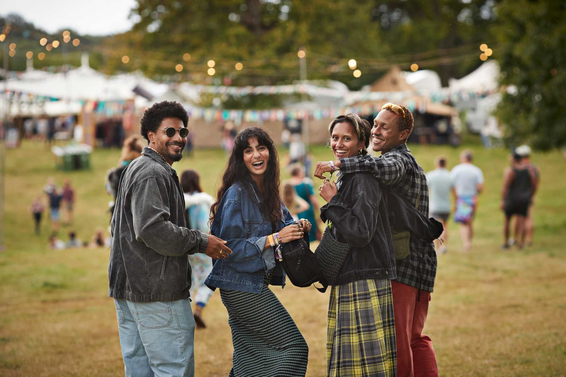 Smiling friends with arms around walking at park