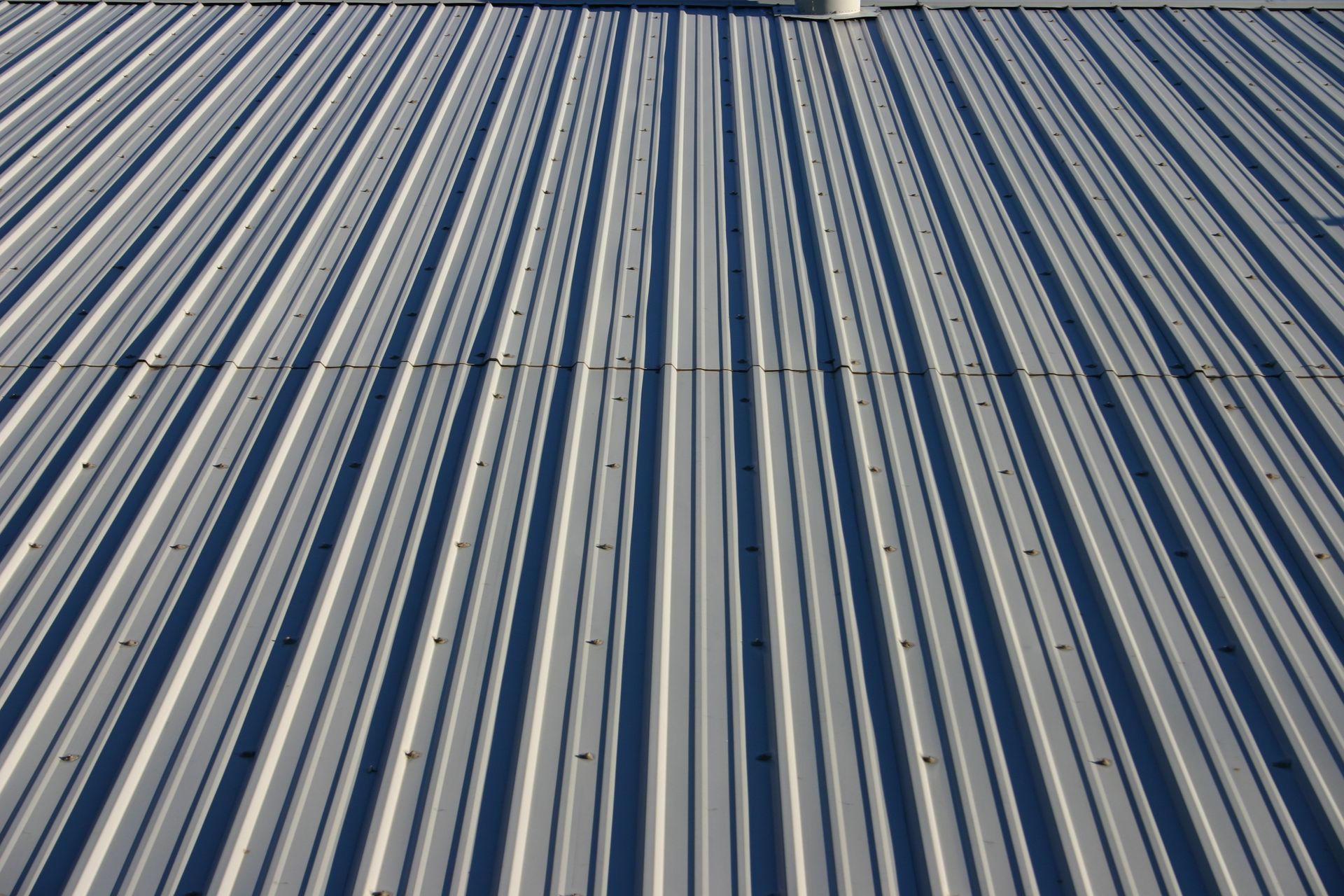 Gray metal corrugated roof, lines receding towards the horizon.
