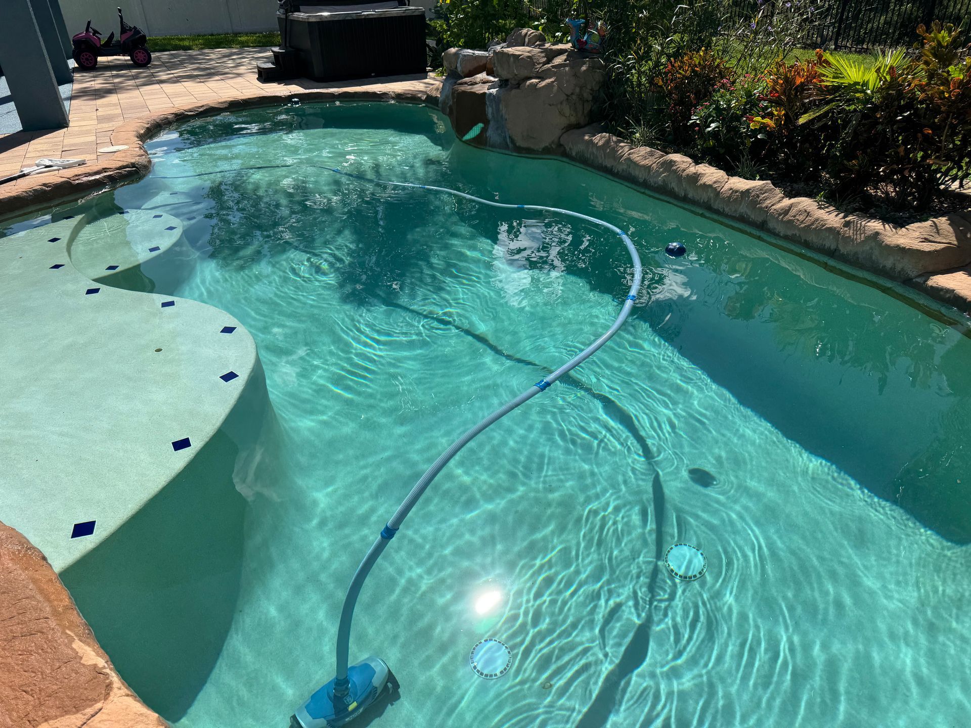 A swimming pool with a vacuum cleaner attached to it.