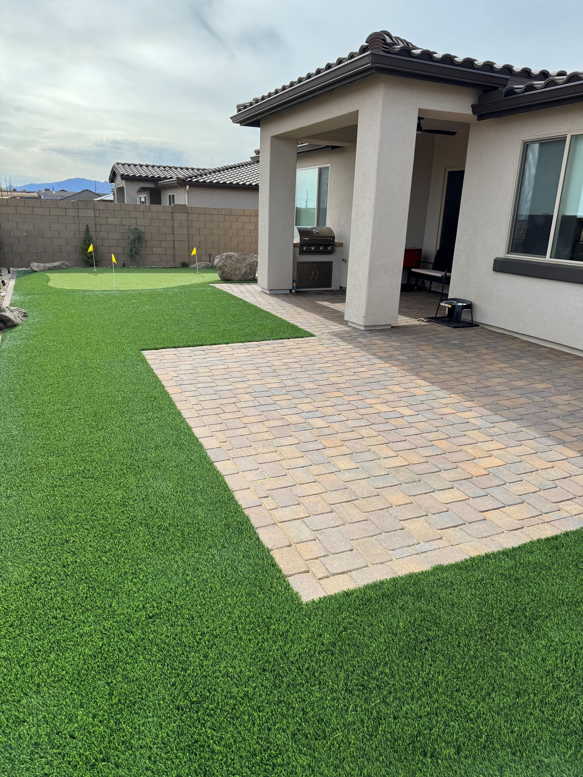 A house with a patio and a lawn in front of it.