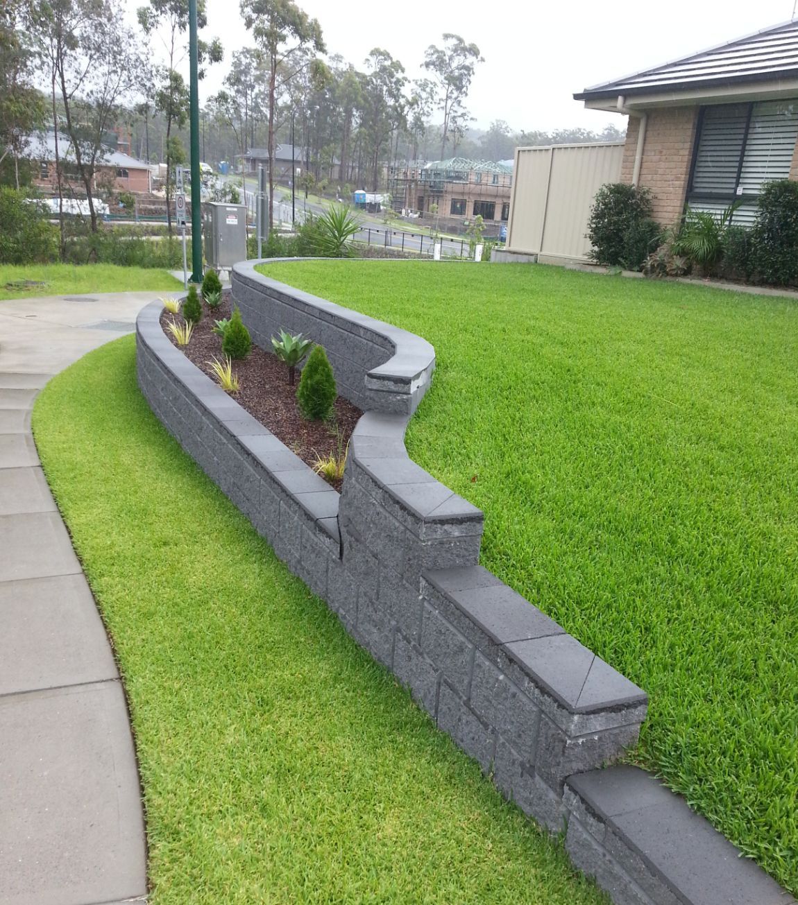 A Brick Wall with A Planter in The Middle of It — Creating Eden Landscaping In Teralba, NSW