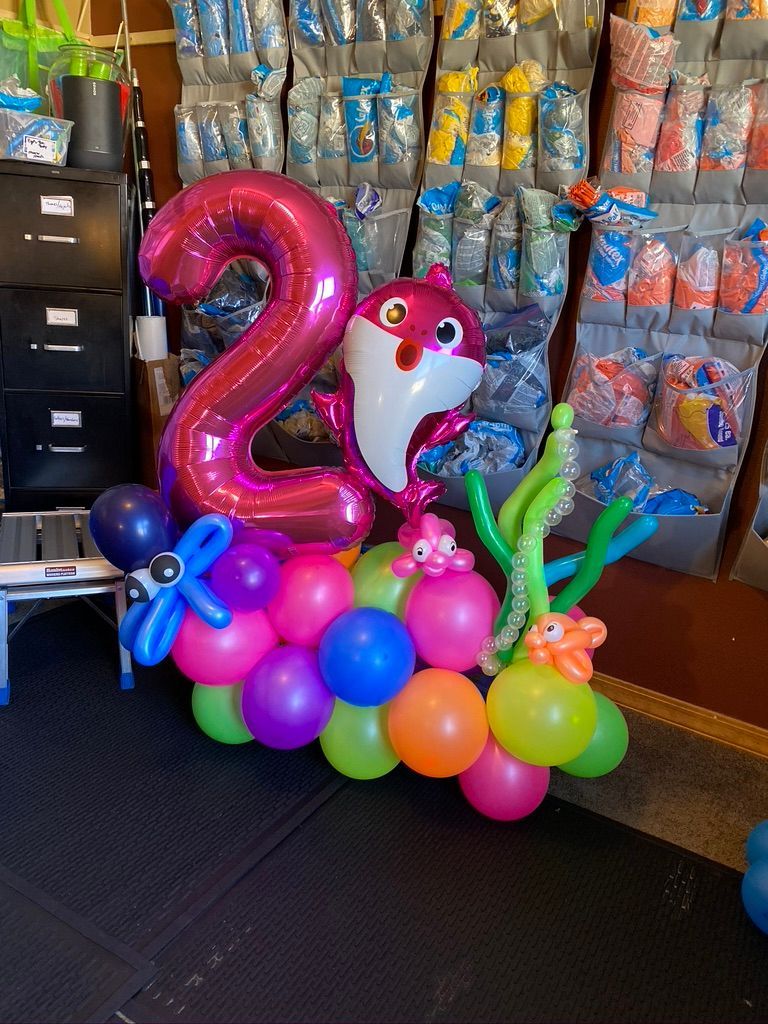 A bunch of balloons are sitting on the floor in a room.