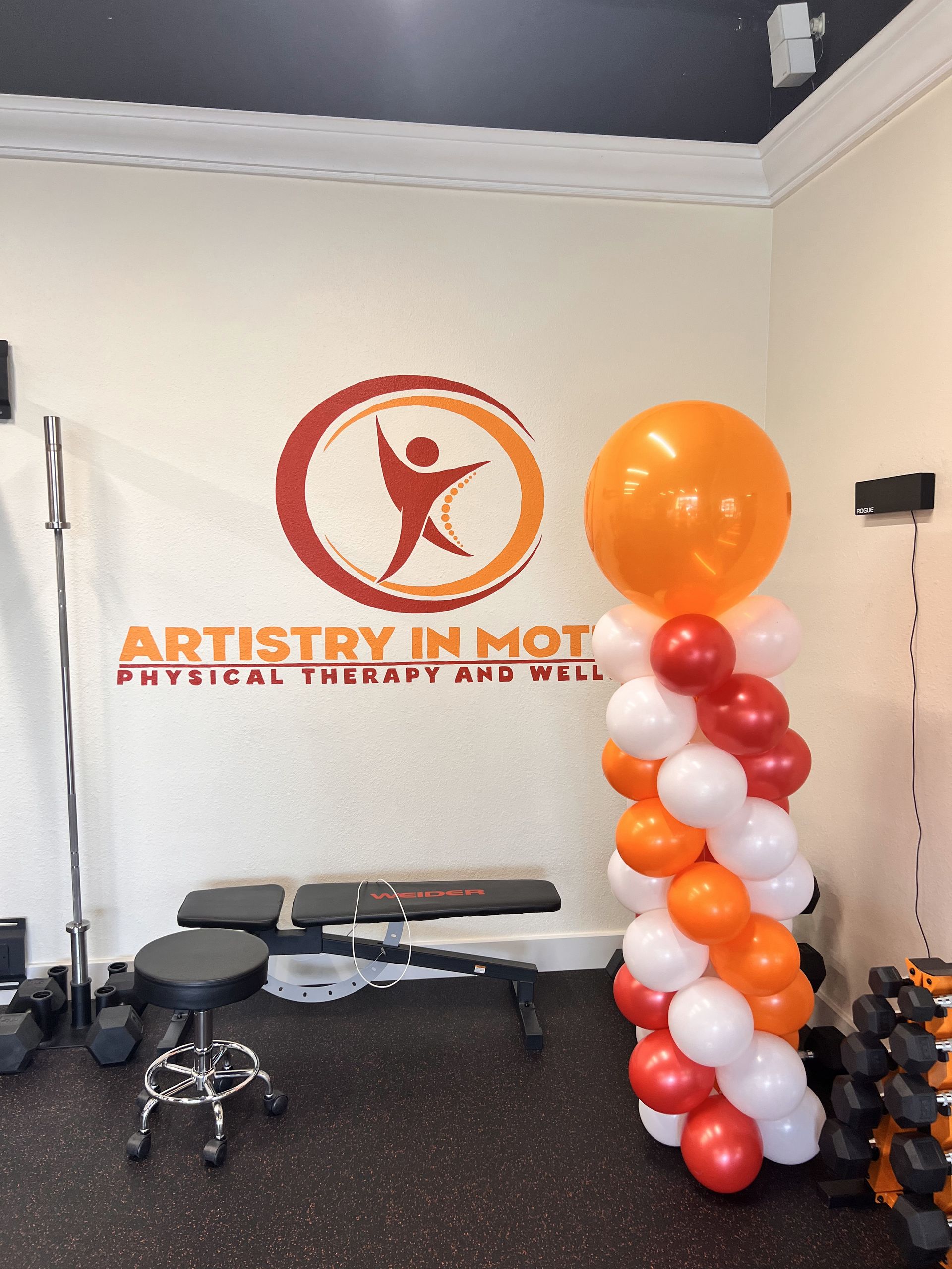 A room with balloons and a sign that says artistry in motion