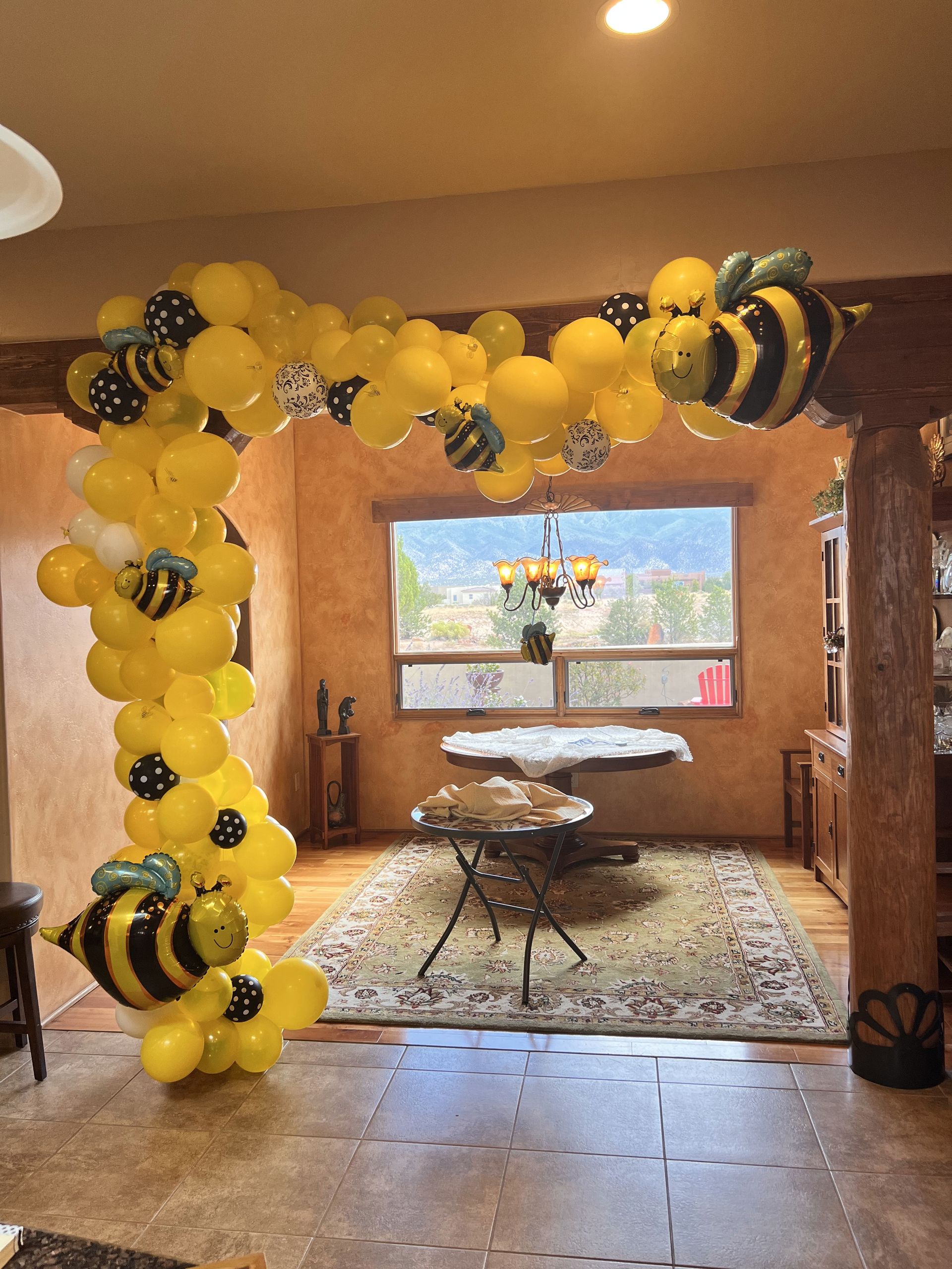 A room decorated with yellow balloons and bees.