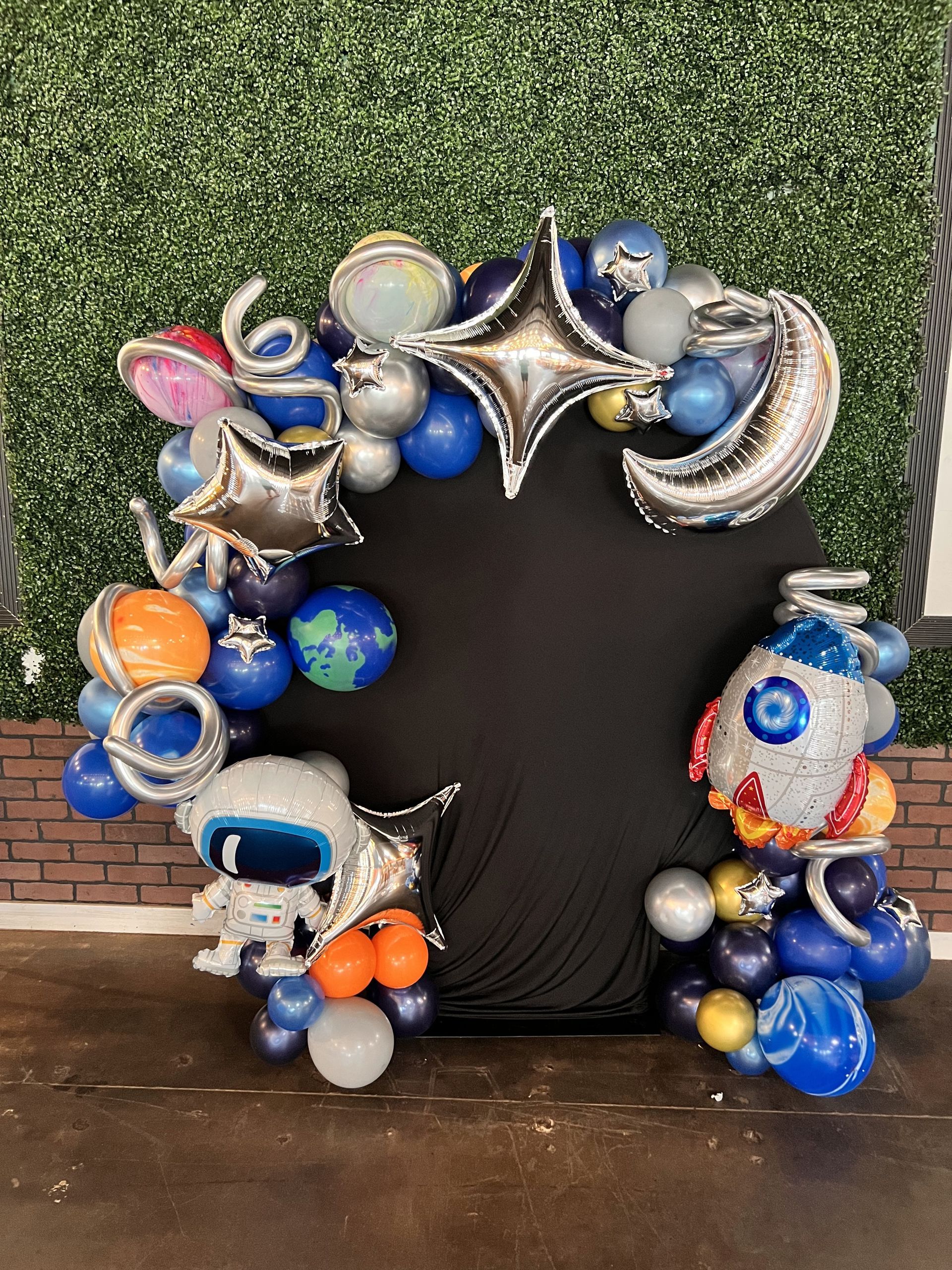 A bunch of balloons are sitting on a table in front of a wall.