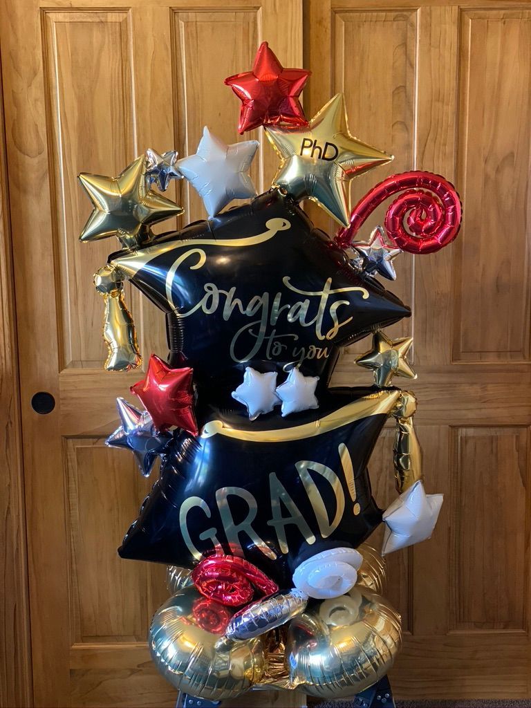 A bunch of balloons are sitting on top of each other in front of a wooden door.