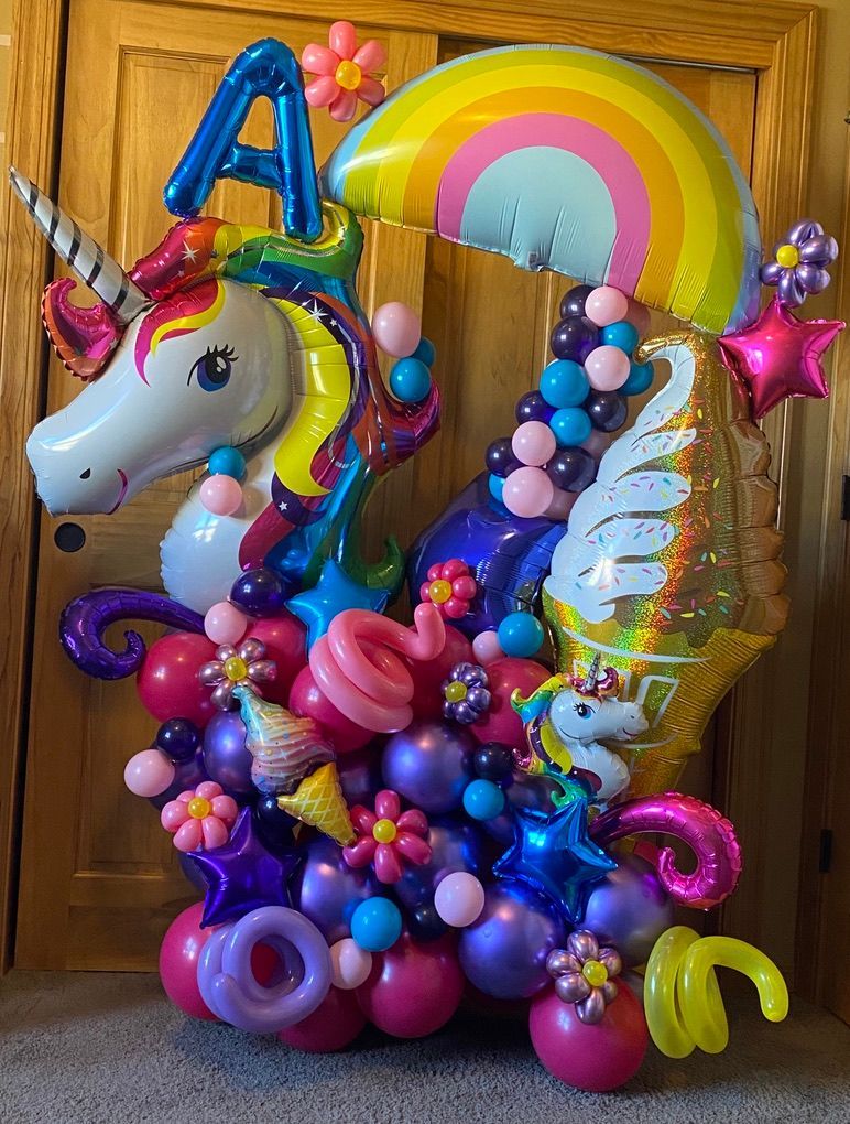 A bunch of balloons in the shape of a unicorn and a rainbow.