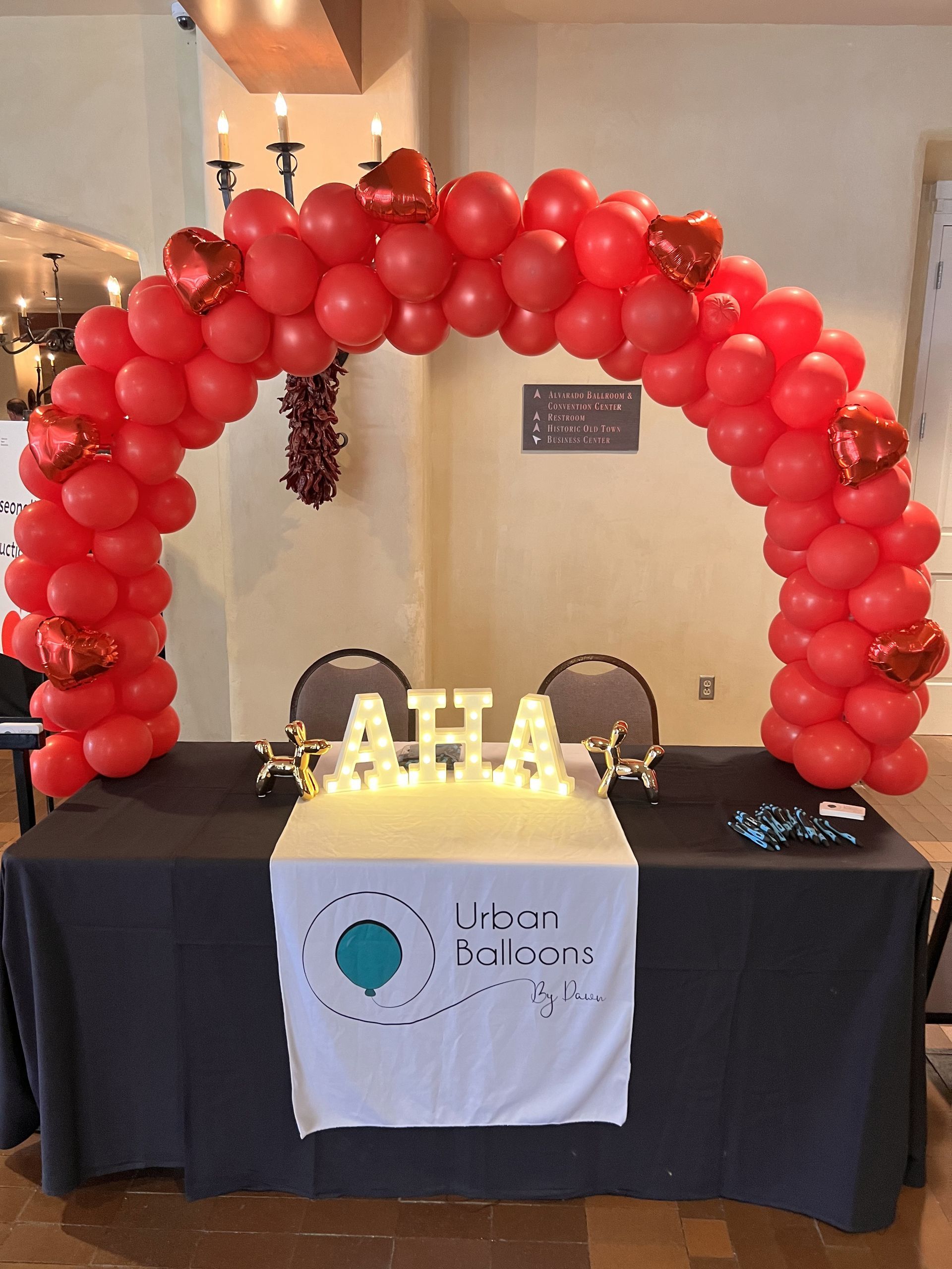 A table with red balloons and a sign that says aha