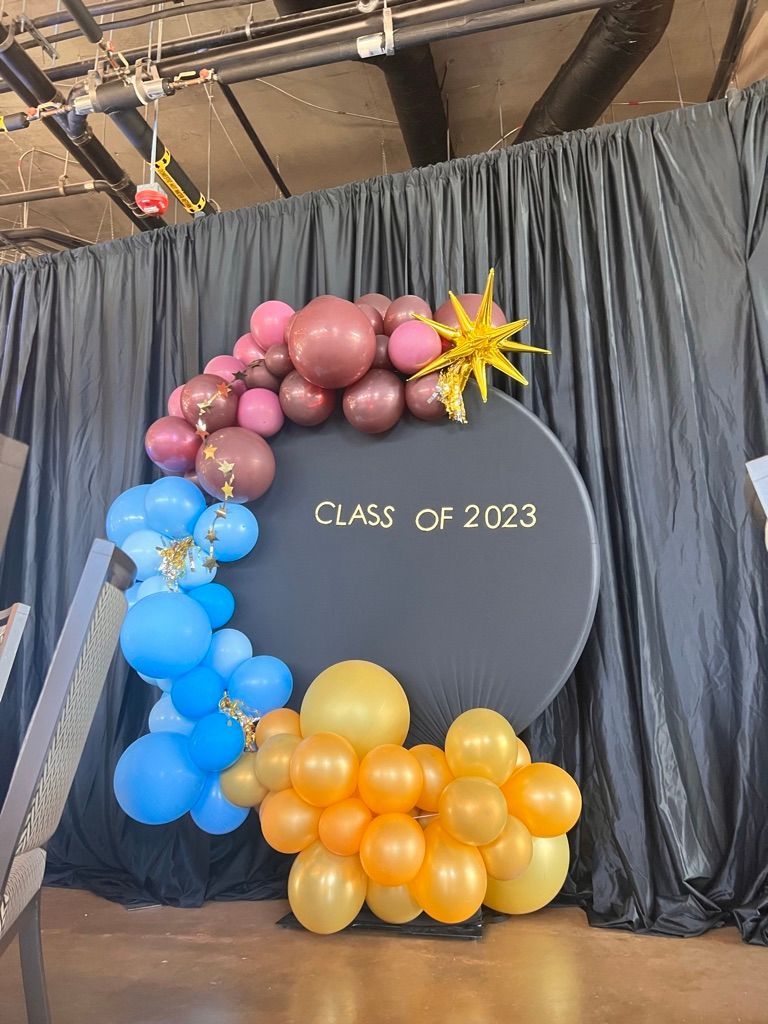 A bunch of balloons are sitting in front of a black curtain.