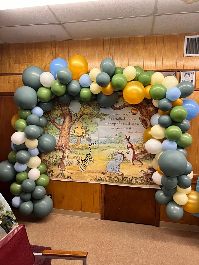 A room filled with balloons and a picture of winnie the pooh on the wall.