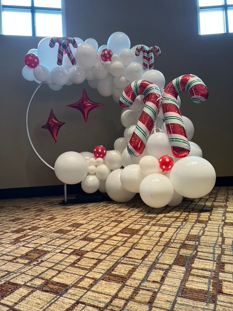 A candy cane made out of balloons in a room.