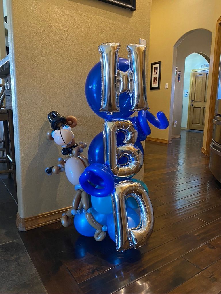 A bunch of balloons are sitting on a wooden floor in a room.