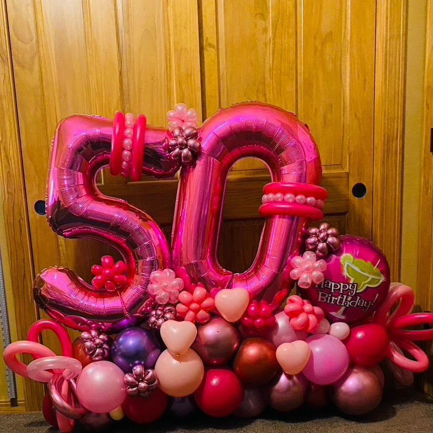 A bunch of pink balloons in the shape of the number 50