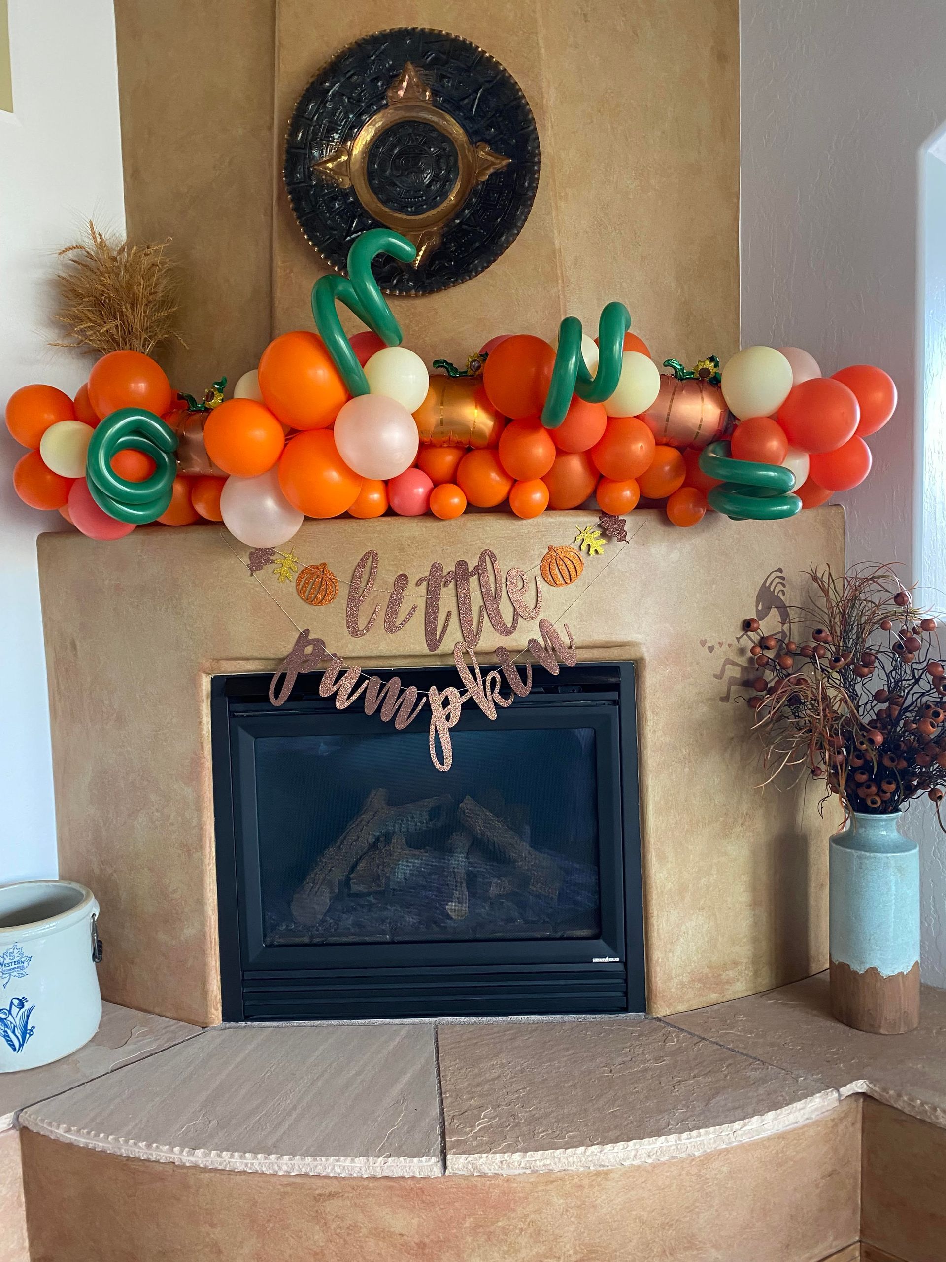 A fireplace with balloons and pumpkins on it