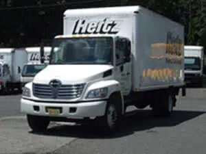 White Hertz box truck parked on asphalt.