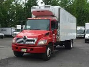 Red refrigerated delivery truck parked outside.
