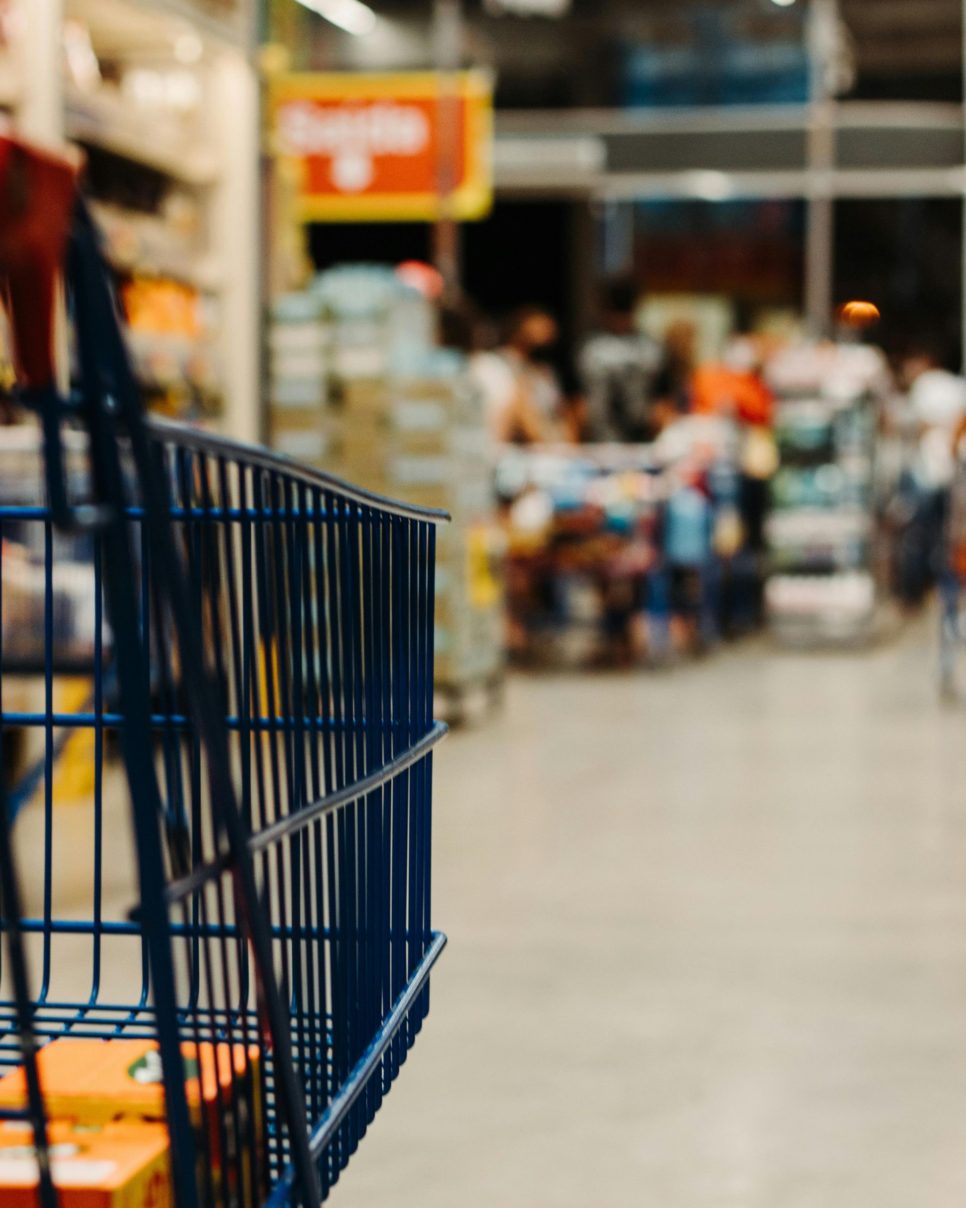 Shopping for protein in a supermarket with blurred shoppers in the background.