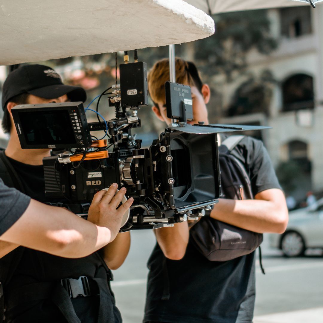 people shooting with a camera outside on the street