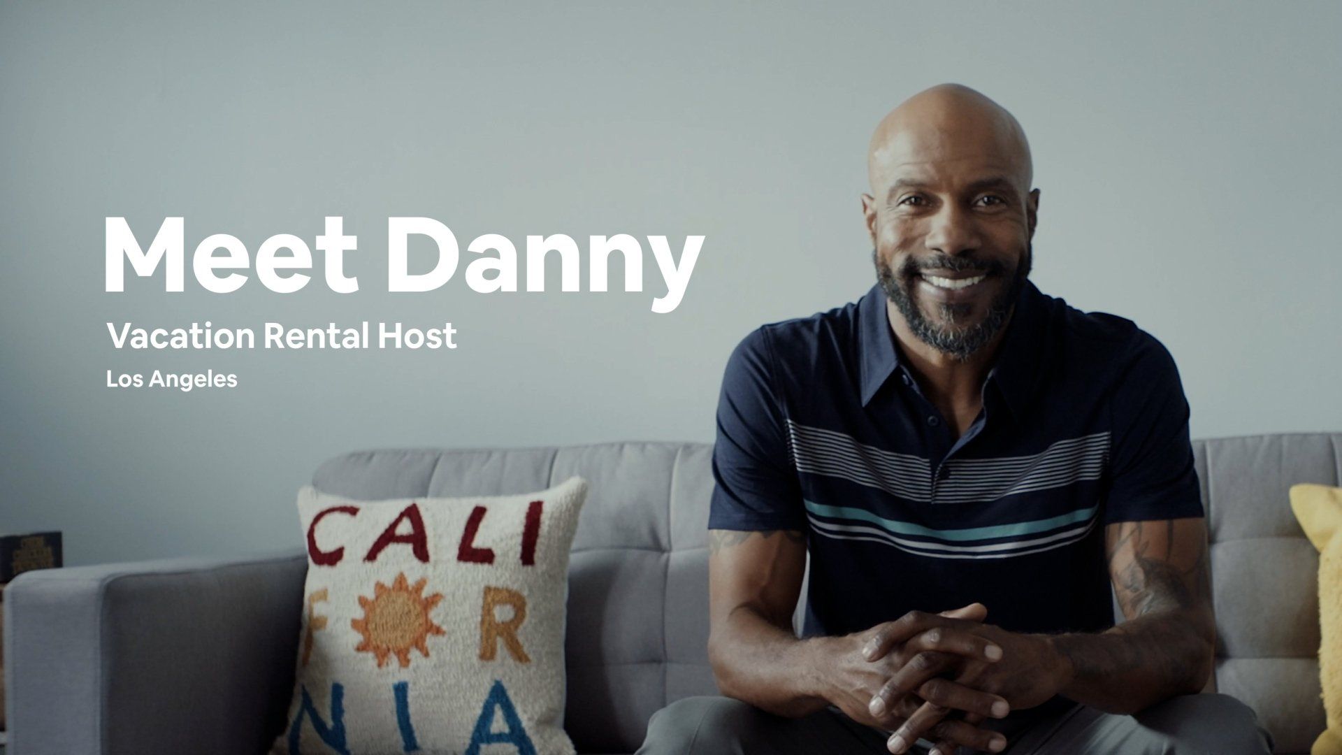 Danny, vacation rental host, seated on a couch in Los Angeles, smiling.