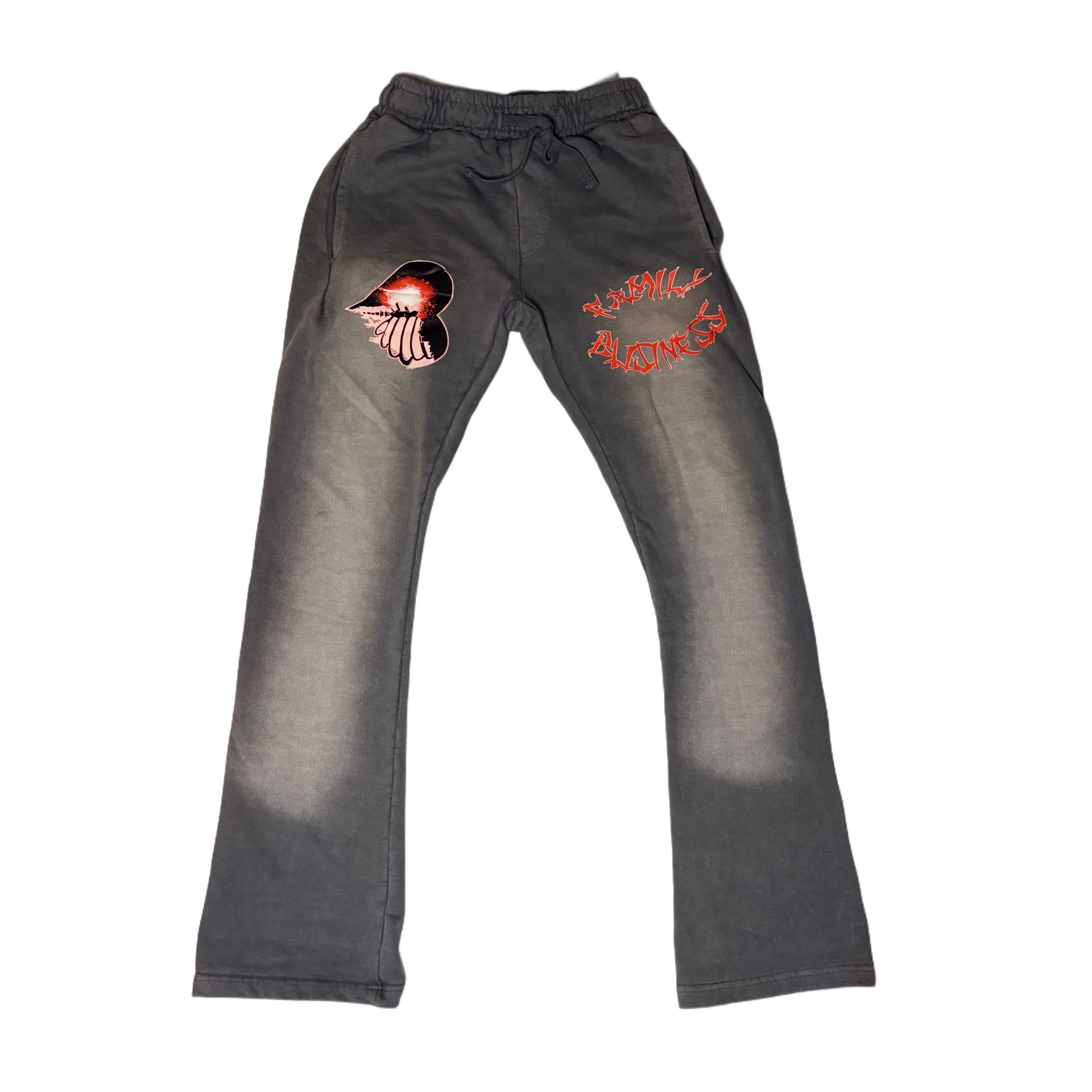 Black sweatpants with red graphic designs on the thighs, laid flat on a white background