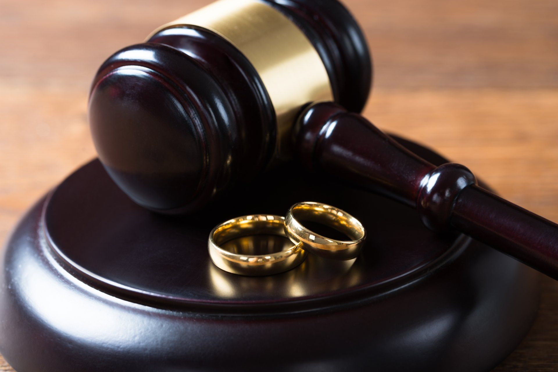 A couple of wedding rings sitting on top of a wooden gavel