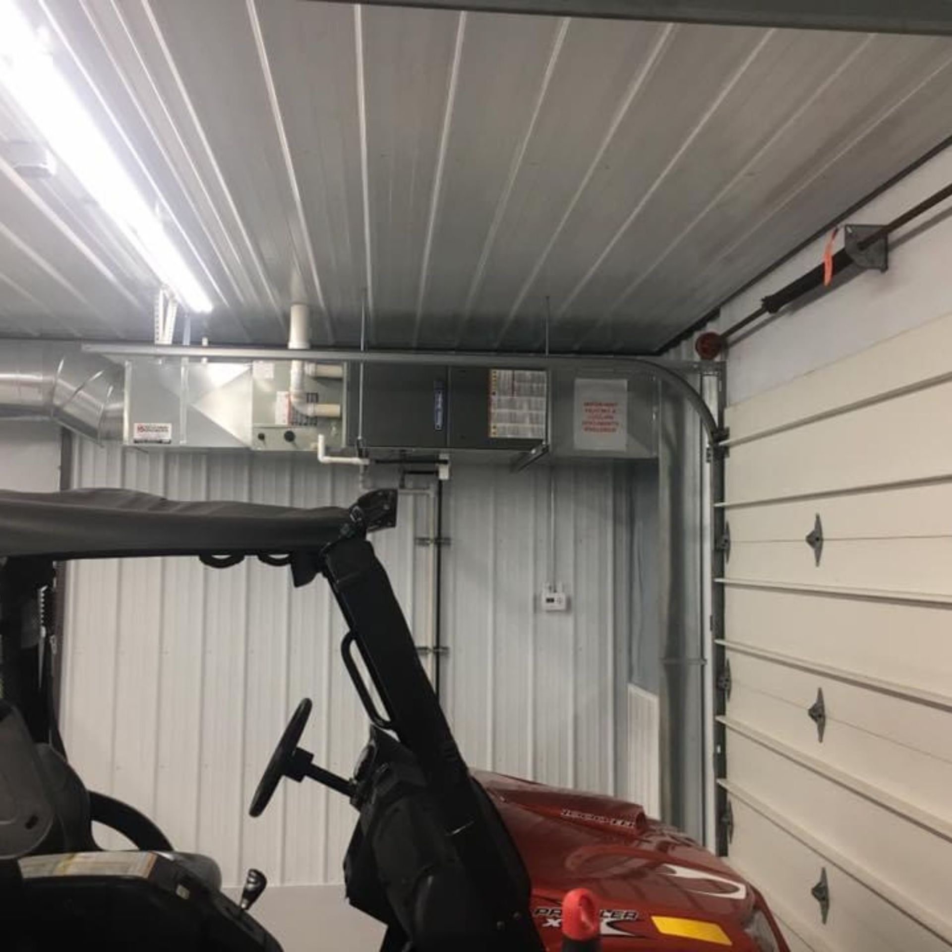 Lake Area Heating and Cooling LLC |A red utility vehicle is parked in a garage
