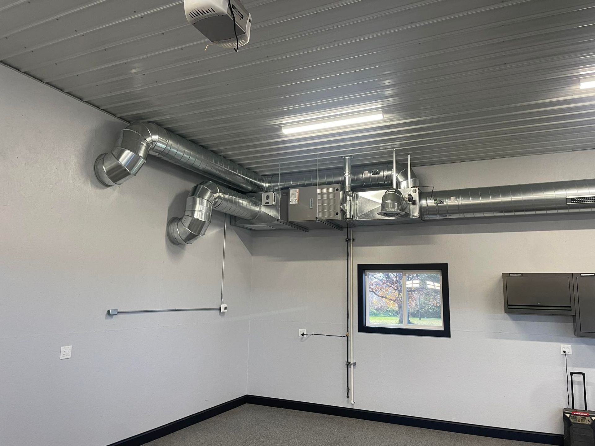Lake Area Heating and Cooling LLC | A garage with a lot of pipes coming out of the ceiling.