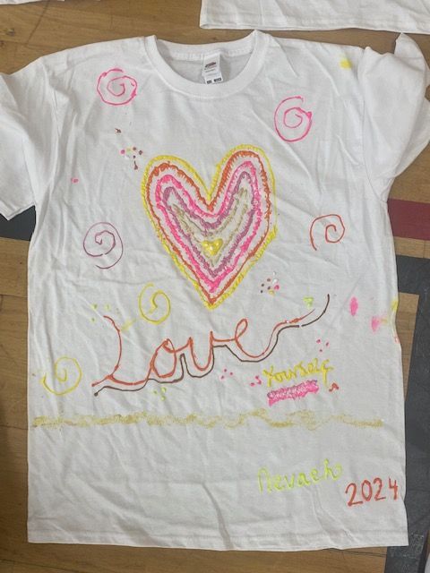 A white shirt with a heart and the word love on it