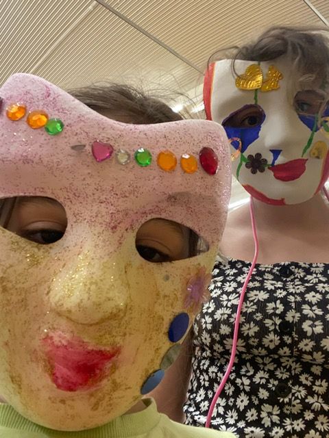 A girl wearing a pink mask and a girl wearing a white mask