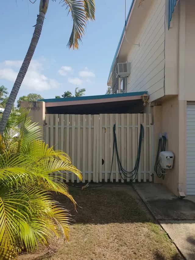 A House With a Fence and a Palm Tree in Front of It — Gaspen Builders & Carpenters in Kirwan, QLD