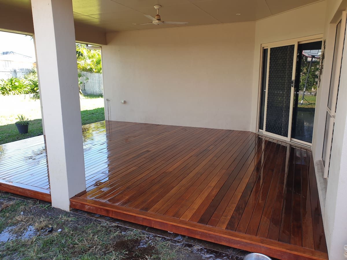 A Wooden Deck With a Sliding Glass Door and a Ceiling Fan — Gaspen Builders & Carpenters in Kirwan, QLD